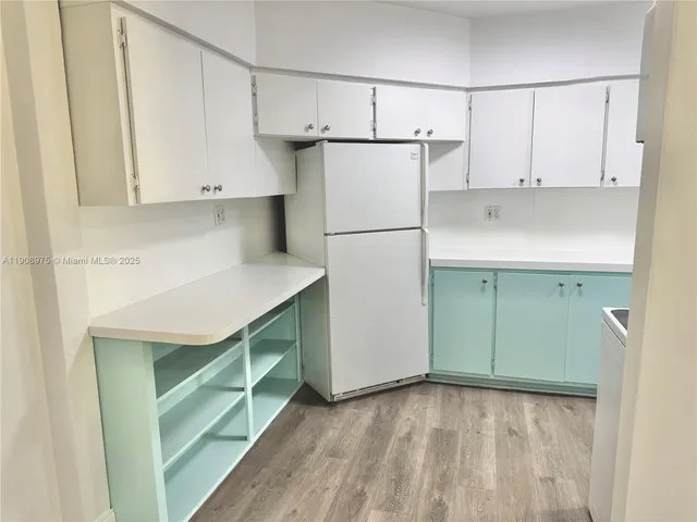 a kitchen with a refrigerator and cabinets