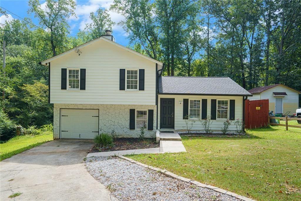 a front view of a house with yard porch and tree
