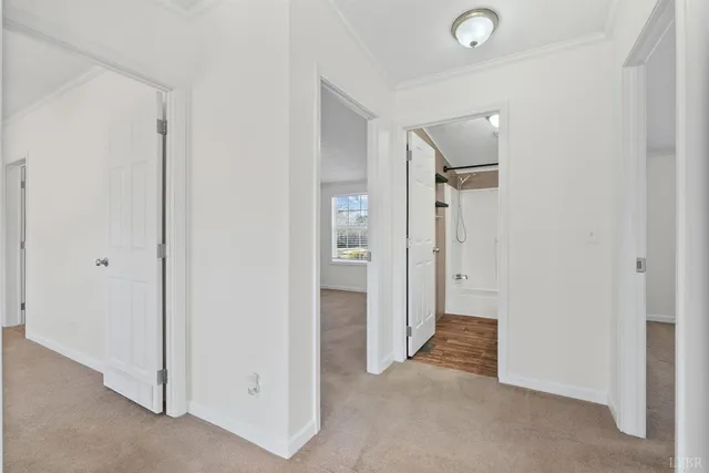 a view of a hallway with closet and a bathroom