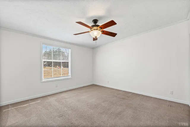 an empty room with a window and a ceiling fan