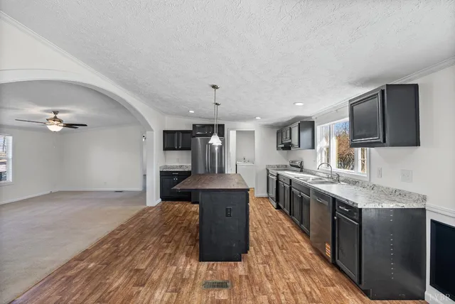 a large kitchen with cabinets wooden floor and stainless steel appliances