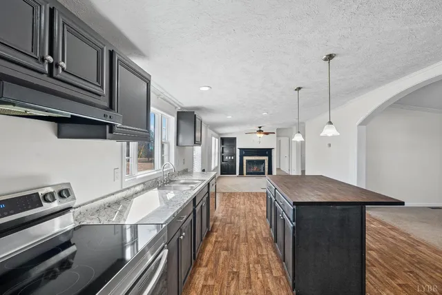 a kitchen with kitchen island a stove and a wooden floor