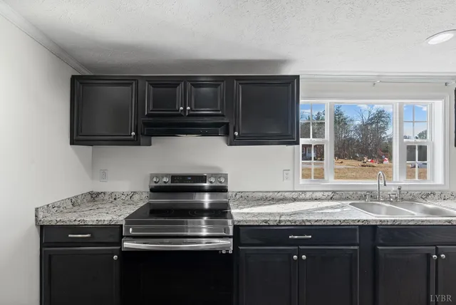 a kitchen with stainless steel appliances granite countertop a sink and a stove