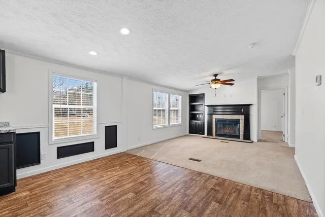 a view of an empty room with a fireplace and a window