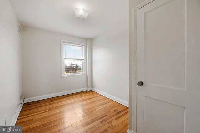a view of a room with wooden floor and a window