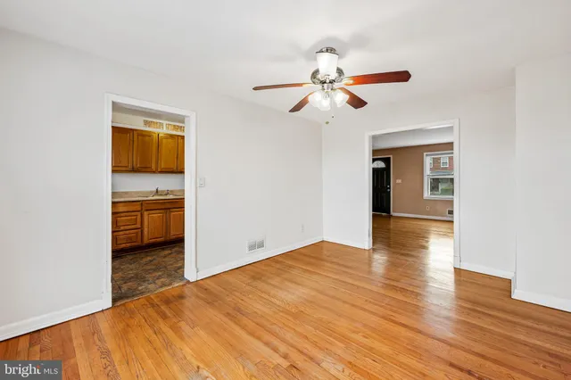 a view of a room with wooden floor a ceiling fan and window