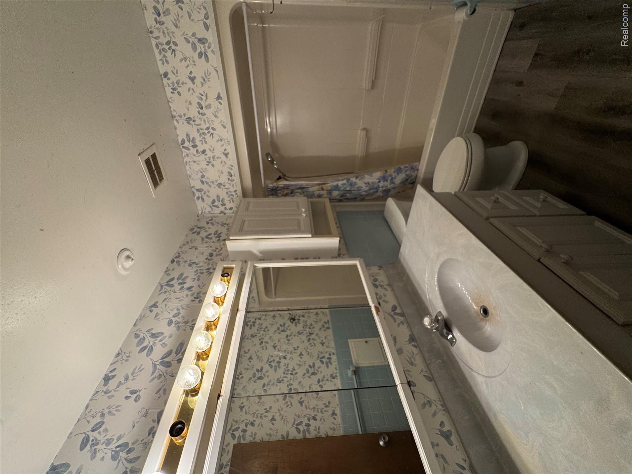 31263 Hayes Road Warren, MI 48088 - Photo 17 of 31 Full bath with vanity, shower / bath combo with shower curtain, wallpapered walls, and dark wood finished floors