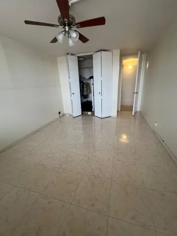 a view of an empty room with a ceiling fan