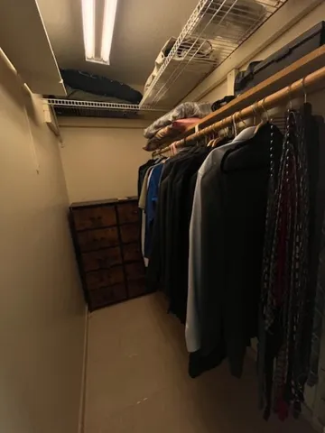 a view of walk in closet with clothes