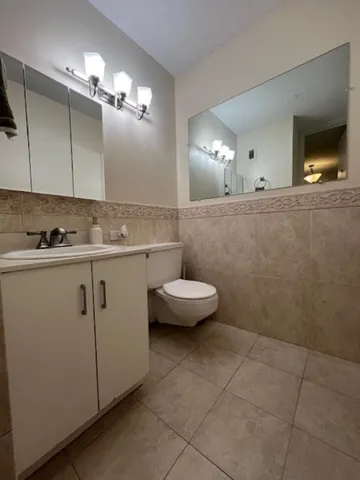 a bathroom with a sink a toilet and mirror