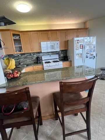 a kitchen with a table chairs and a stove in it