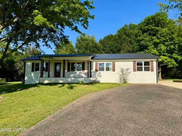 front view of a house with swimming pool and porch with green space