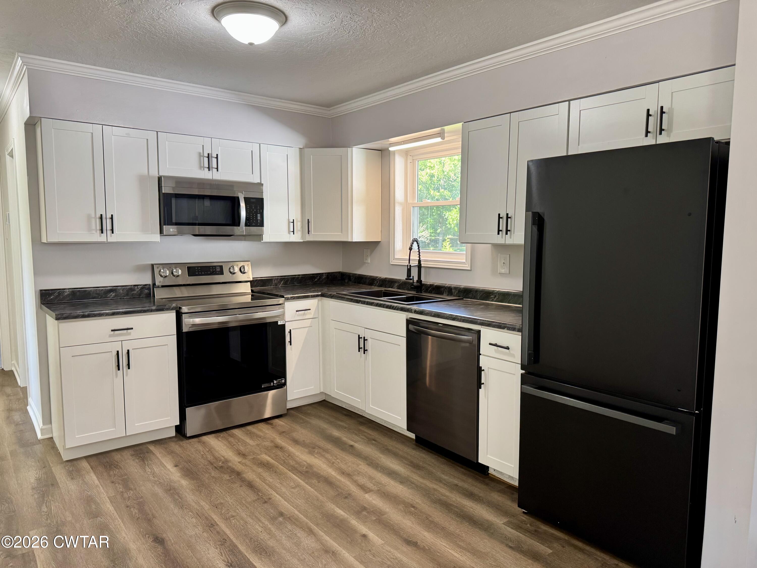 98 Reagan Road Dyersburg, TN 38024 - Photo 22 of 31 a kitchen with a refrigerator stove and sink