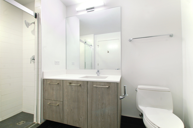 Undisclosed Address Chicago, IL 60657 - Photo 16 of 17 a bathroom with a granite countertop toilet a sink and a mirror