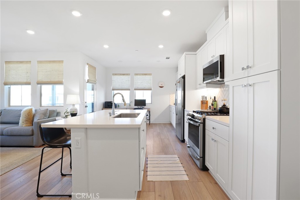 1300 Lasso Way, Unit 301 Rancho Mission Viejo, CA 92694 - Photo 4 of 17 a kitchen with stainless steel appliances kitchen island granite countertop a sink and cabinets