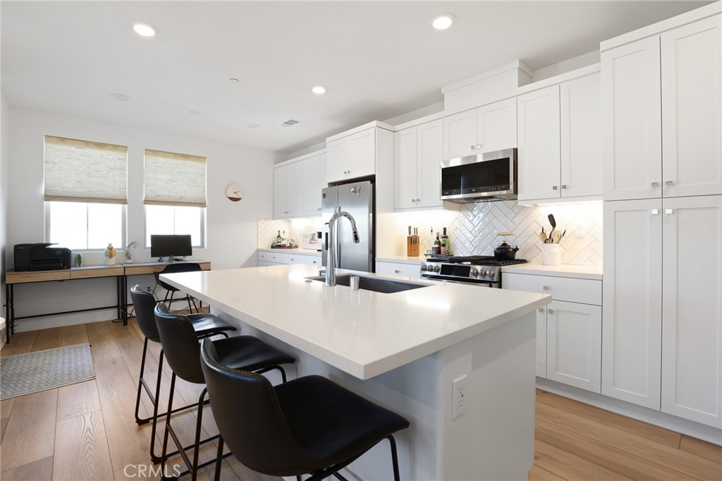1300 Lasso Way, Unit 301 Rancho Mission Viejo, CA 92694 - Photo 5 of 17 a kitchen with a sink a stove a microwave and cabinets