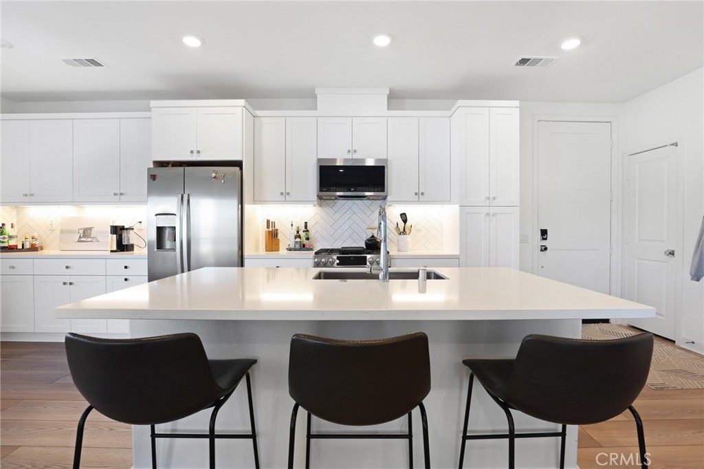 1300 Lasso Way, Unit 301 Rancho Mission Viejo, CA 92694 - Photo 6 of 17 a kitchen with stainless steel appliances a dining table chairs and refrigerator