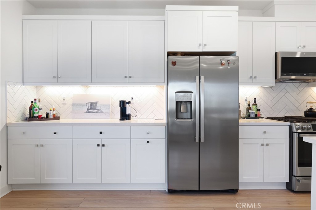 1300 Lasso Way, Unit 301 Rancho Mission Viejo, CA 92694 - Photo 7 of 17 a kitchen with cabinets stainless steel appliances and wooden floor