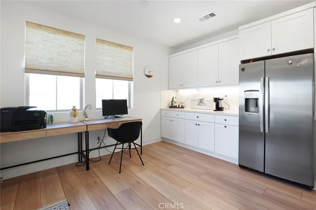 a kitchen with cabinets stainless steel appliances and wooden floor