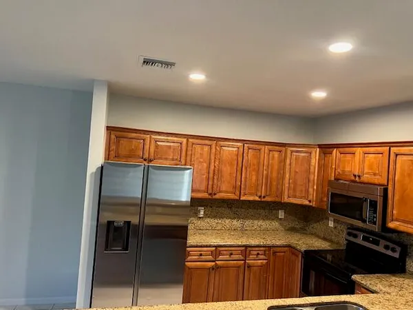 a kitchen with stainless steel appliances granite countertop a stove and a refrigerator