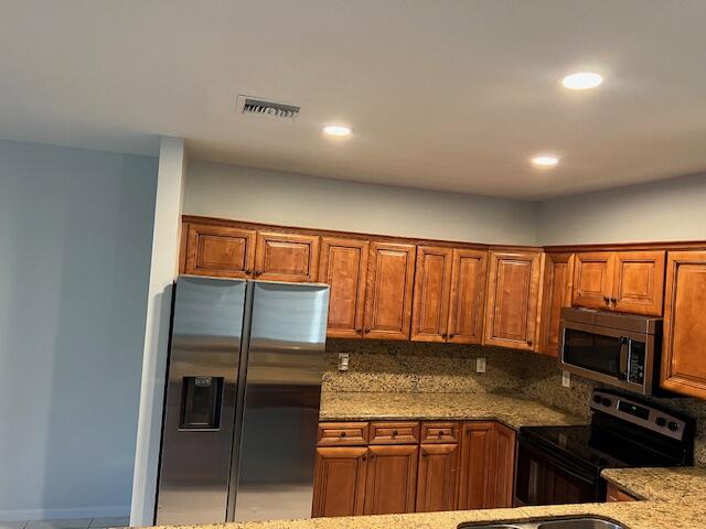 140 Baldwin Boulevard Greenacres, FL 33463 - Photo 5 of 18 a kitchen with stainless steel appliances granite countertop a stove and a refrigerator