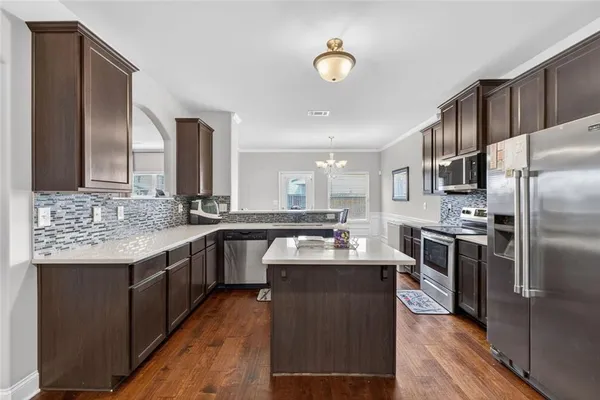 a kitchen with stainless steel appliances granite countertop a sink stove and refrigerator