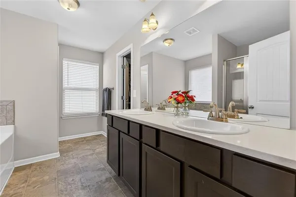 a spacious bathroom with a tub sink and mirror