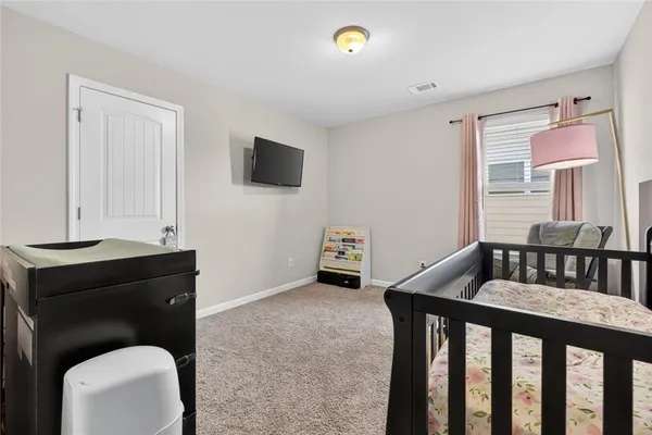 a bedroom with a bed and a flat tv screen on the dresser
