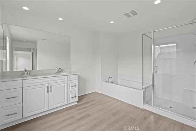 a spacious bathroom with a shower a sink and a mirror