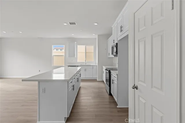 a view of a kitchen with a sink and wooden floor