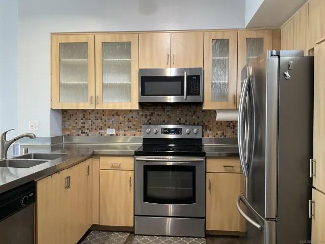 a kitchen with stainless steel appliances granite countertop a stove a refrigerator and a sink