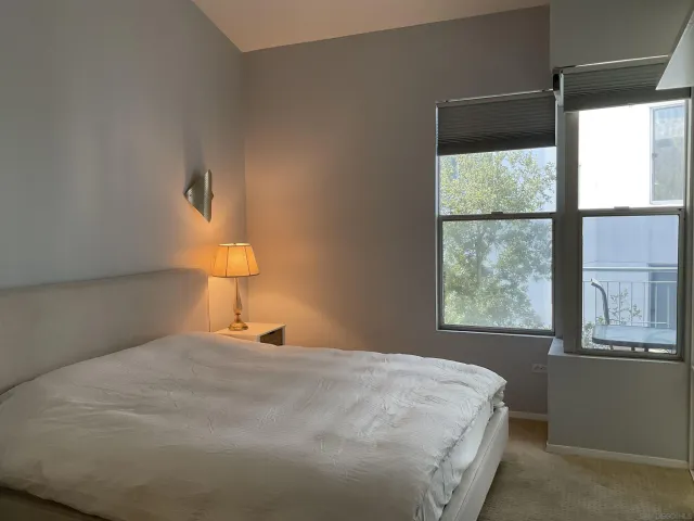 a bedroom with a bed and a lamp next to a window