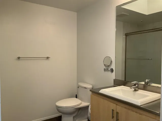 a bathroom with a sink mirror vanity and toilet