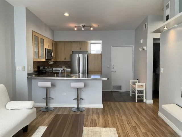 a kitchen with stainless steel appliances a refrigerator and wooden floor