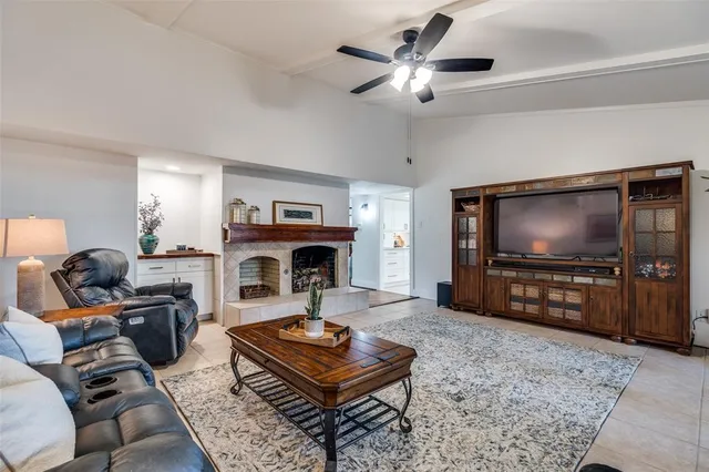 a living room with furniture a flat screen tv and a table