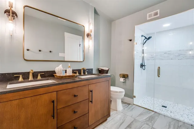 a bathroom with a granite countertop sink mirror and a toilet