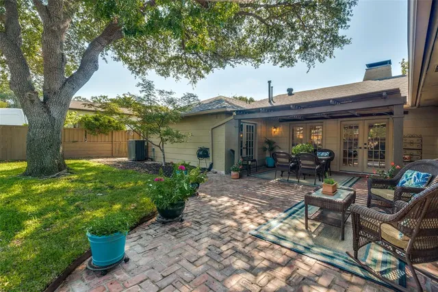 a view of a patio with table and chairs potted plants and a large tree