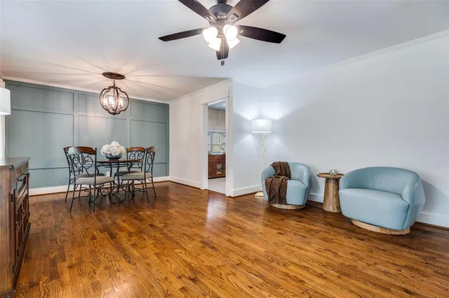 a dining room with furniture a chandelier and wooden floor