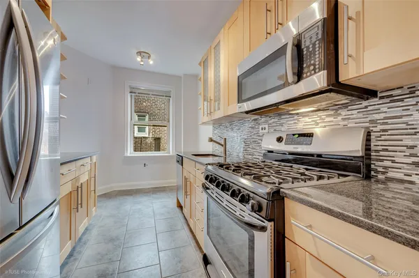 a kitchen with stainless steel appliances granite countertop a stove and a microwave