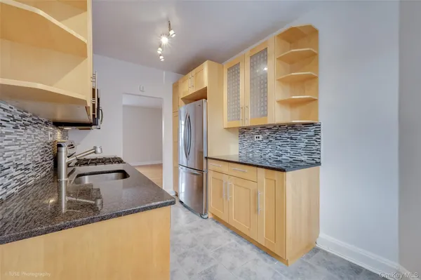 a kitchen with stainless steel appliances granite countertop a sink and a refrigerator