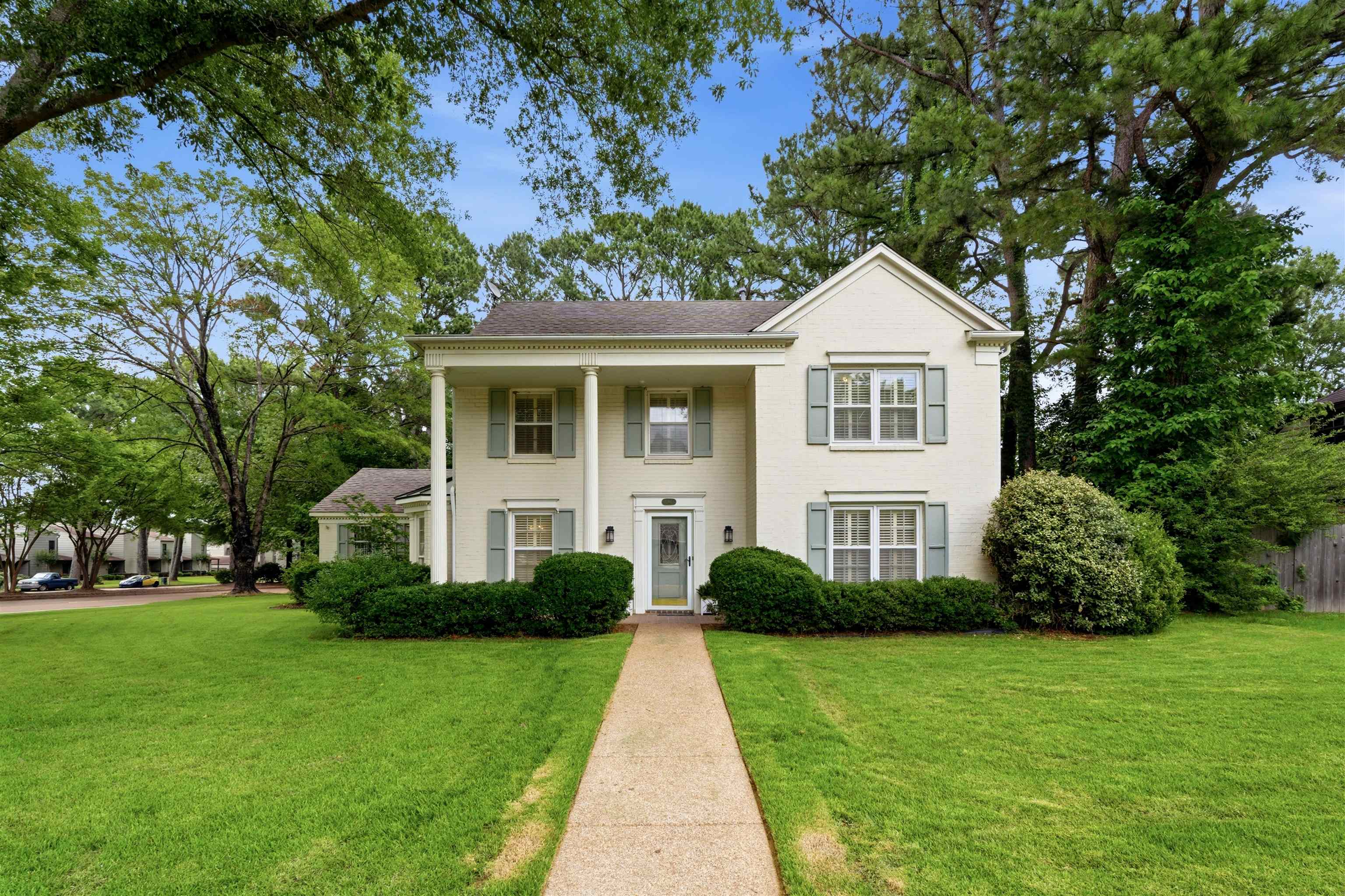 Traditional two-story exterior with a cream facade and a gray shingled roof