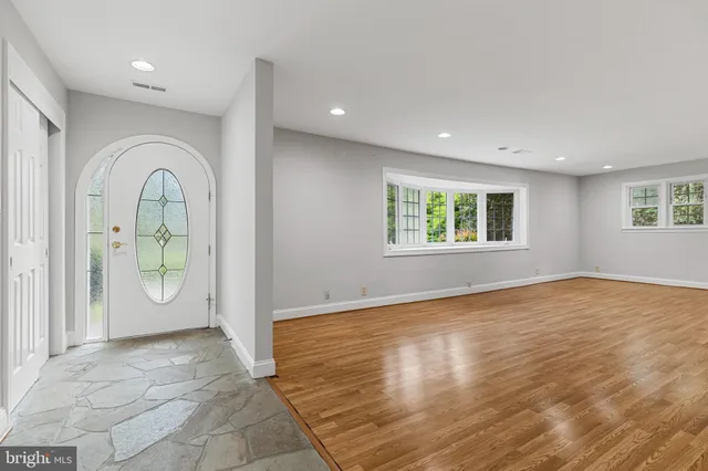 a view of an empty room with window and wooden floor