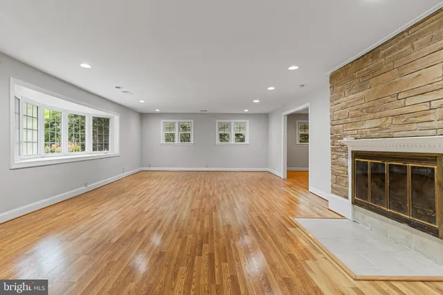 a view of empty room with wooden floor and fireplace