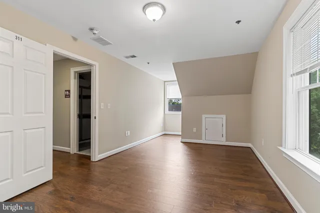 a view of an empty room with wooden floor