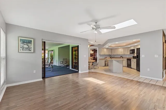 a view of a big room with wooden floor and a kitchen