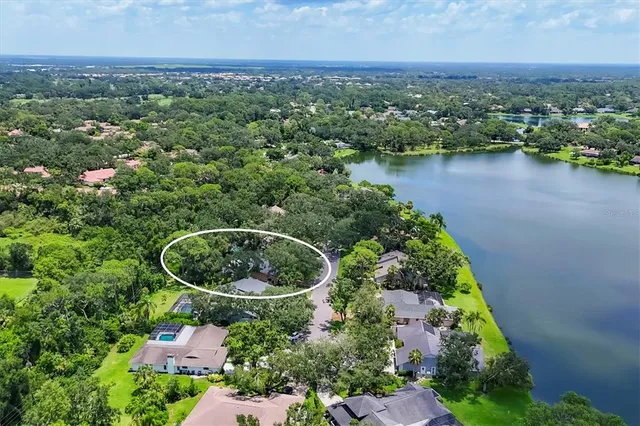 an aerial view of a house with outdoor space and lake view in back