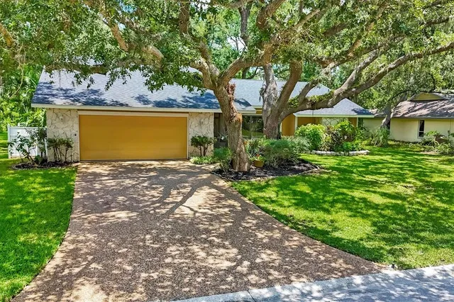 a front view of a house with a yard and a garden
