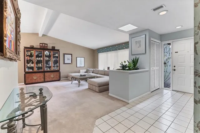 a living room with furniture a window and a potted plant