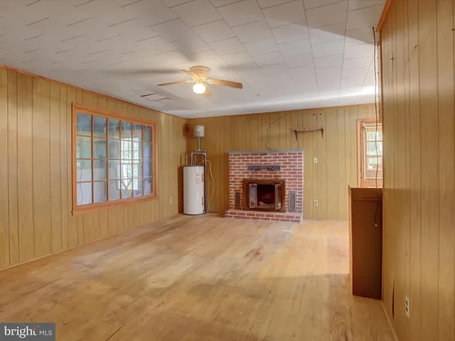 a view of an empty room with a fireplace and a window