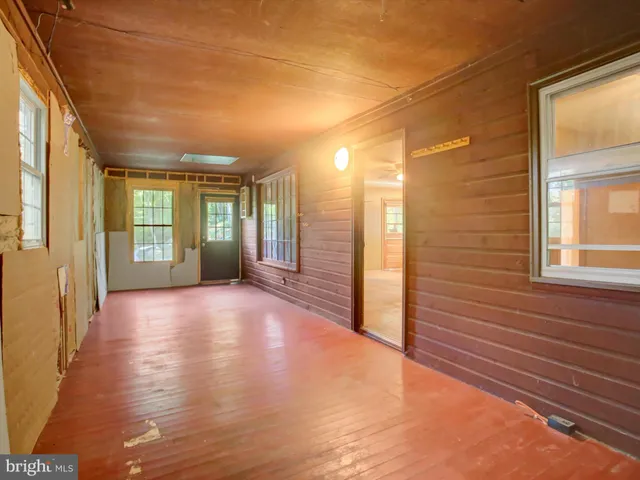 a view of a hallway with wooden floor and a window